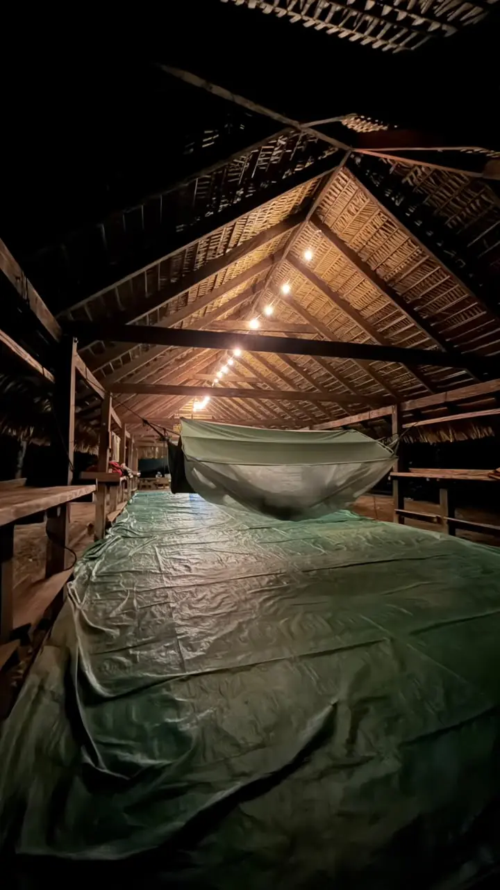 Hammock with mosquito net under the thatched roof at Mapari Wilderness Camp at night